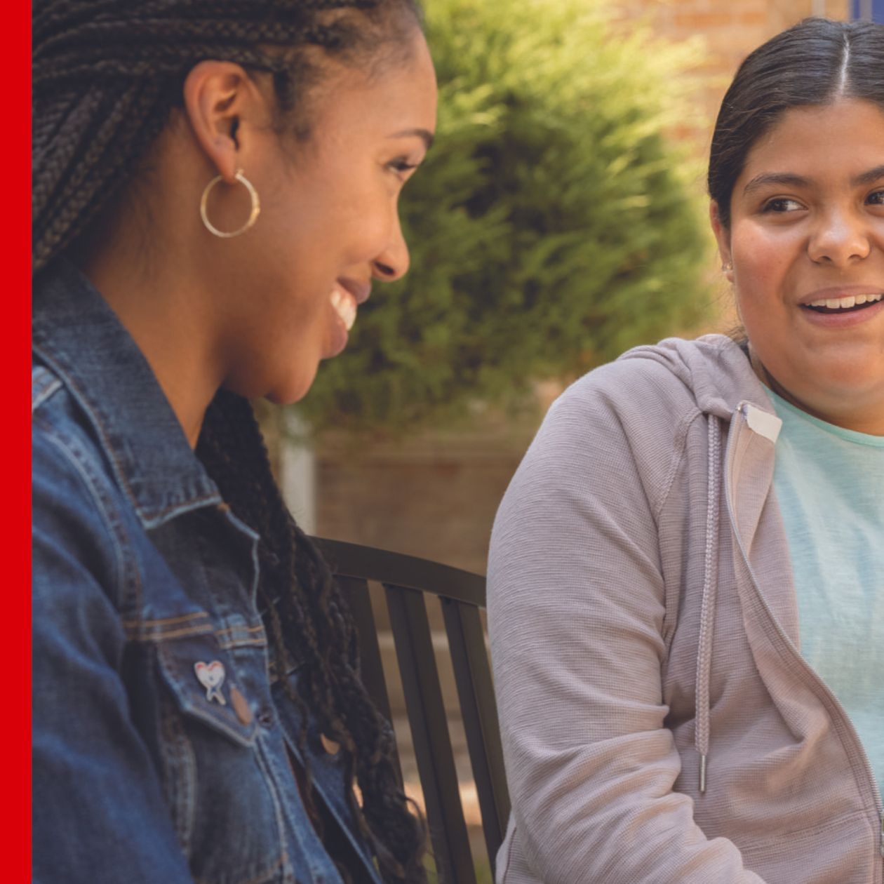 adult speaking with young woman on bench, blog header
