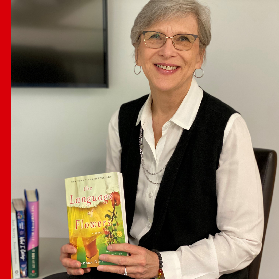 CASA staff holding The Lanaguage of Flowers by Vanessa Diffenbaugh