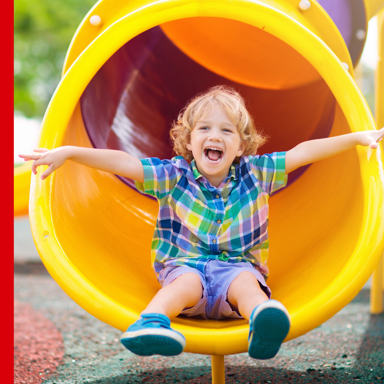 child on slide smiling